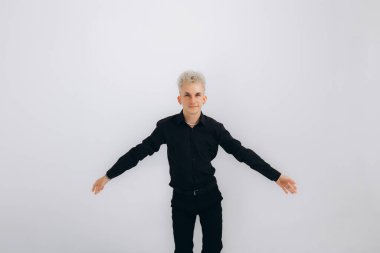 Siyah giyen bir adam beyaz arka planda salsa, zouk, kizomba yapar. 