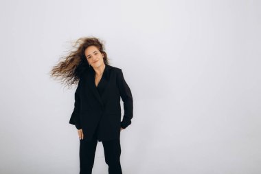 Siyah dans eden bir kadın, beyaz arka planda salsa, zouk, kizomba yapar. 