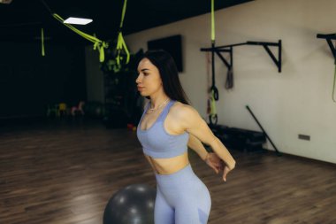 Güzel bir genç bayan spor salonunda çalışıyor.