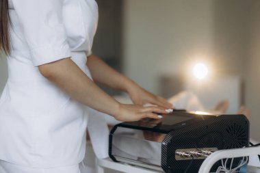 Kadın masaj terapisti, içinde masaj aleti olan bir çantayı açar.