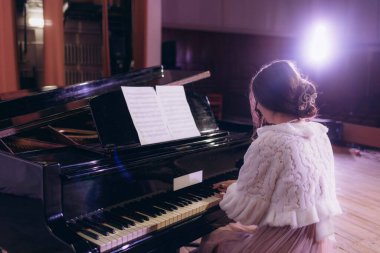 Evin içinde beyaz perdelerle piyano çalan güzel bir kadın..