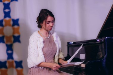 Konserden önce sahnede bir kadın piyanoda notaları tekrarlıyor.