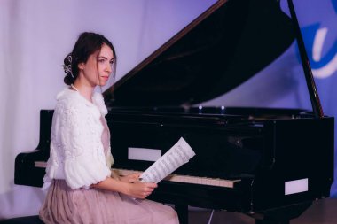 Piyanoda notları olan bir kadının portresi.