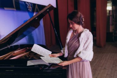 Nota okuyarak piyano çalan kadınların ellerini kapatın. Seçici odak