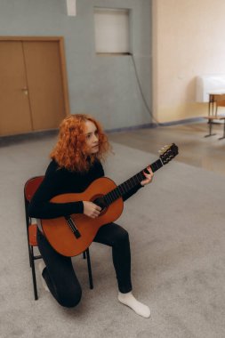 Bir müzik stüdyosunda gitar çalan güzel bir kadın enstrümana odaklanmış..