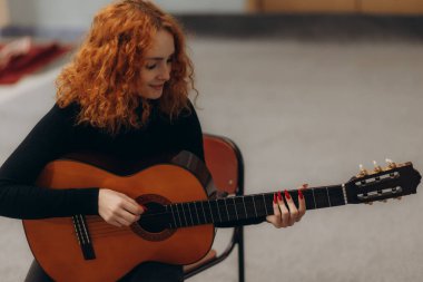 Bir müzik stüdyosunda gitar çalan güzel bir kadın enstrümana odaklanmış..