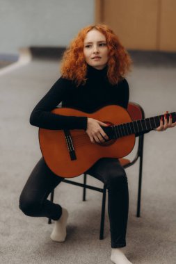 Bir müzik stüdyosunda gitar çalan güzel bir kadın enstrümana odaklanmış..