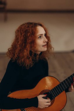 Kapıcıyı oynayan kızıl saçlı bir kadının portresi