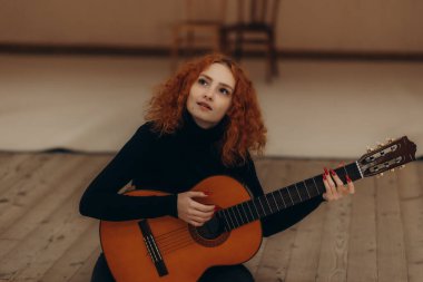 Kapıcıyı oynayan kızıl saçlı bir kadının portresi