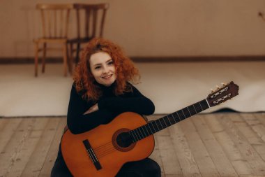 Young redhead woman musician smiling confident playing classical guitar at music studio