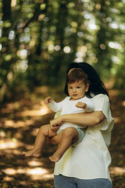 Bir anne oğlunu bir yaz parkında kollarına alır.