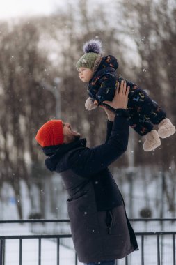 Baba ve oğul kışın dışarıda eğlenirler.