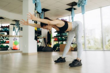 fitness, spor, eğitim, spor ve yaşam kavramı - kulaklık ile genç kadın spor salonunda germe