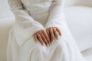 Close-up of the bride's hands on a white wedding dress clipart