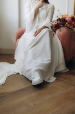 Gelinlik giymiş beyaz spor ayakkabılı gelinin yakın çekimi.