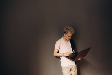 Bir insan, bir dizüstü bilgisayara odaklanmış, verimlilik ve çağdaş profesyonel bir ortam sunan loş bir alanda gelişigüzel durur..