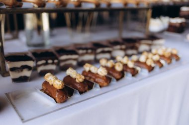 Üzerinde patlamış mısır ve katmanlı tatlı bardaklarının bulunduğu lezzetli bir tatlı masası sofistike bir düzende, düğünler, kutlamalar ve lüks toplantılar için mükemmel..