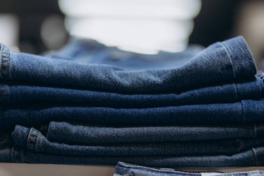 Düzenli katlanmış kot pantolonlar perakende satış ortamında gündelik kıyafetlere vurgu yapıyor..