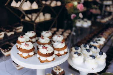 Lezzetli ve ustalıkla tasarlanmış hamur işleri özel bir durum için beyaz kaideye yerleştirilmiş, atmosferi geliştirmiş ve lüks bir görsel ve aşçılık deneyimi sağlamıştır..