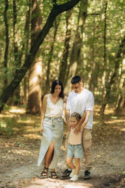 Bereketli bir orman ortamının ortasında sakin bir yürüyüş sırasında sevgi dolu bir aile birlikte vakit geçiriyor. Barışçıl bir açık hava ortamında birliktelik ve doğa keşfi kavramını vurgulamak.