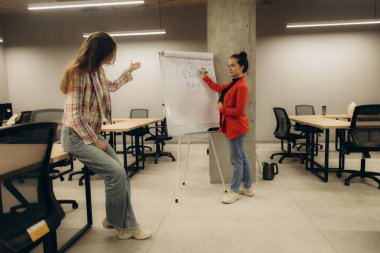 Çağdaş bir ofis ortamında iki birey ortak bir tartışma ve sunum gerçekleştiriyor..