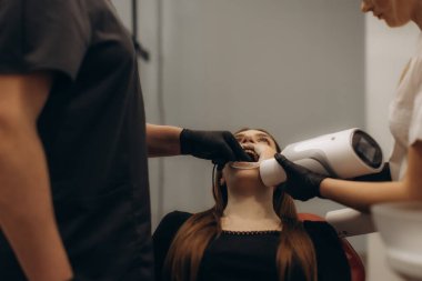 Modern bir klinikte diş taramasından geçen bir hastanın görüntüsü..