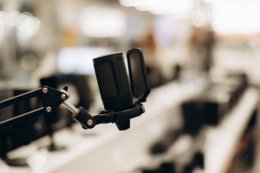 Ses kayıt cihazları ve cihazların sergilendiği çağdaş bir elektronik mağazasında sergilenen yüksek kaliteli bir mikrofonun odaklanmış görüntüsü.