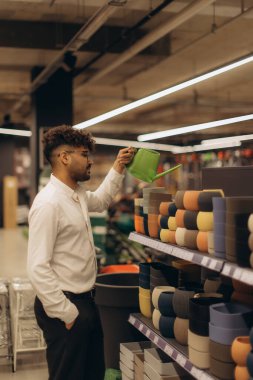 Müşteri, modern bir perakende mağazasının raflarında parlak ışık altında sergilenen canlı ekicileri inceliyor..