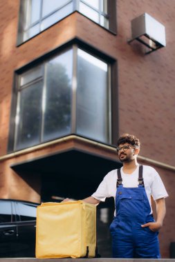 Kurye, müşterilere termal bir sırt çantası, teslimat hizmeti ve küçük işletme konseptiyle yiyecek getiriyor.