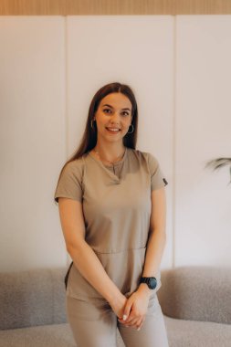 Güzellik salonunda poz veren gülümseyen bir güzellik uzmanının portresi güzellik endüstrisinde profesyonellik ve uzmanlık gösteriyor.