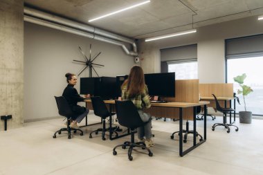 Çalışma masalarında çalışan profesyonellerle çağdaş ofis ayarları, ortak bir alanda işbirliği ve üretkenliği teşvik etmek.