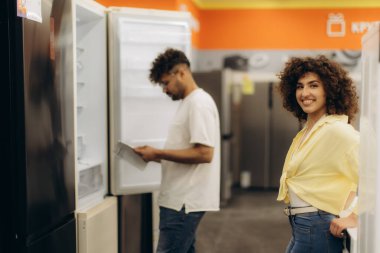 Havalı bir çift, parlak, modern bir elektronik mağazasında buzdolabına karar veriyor..