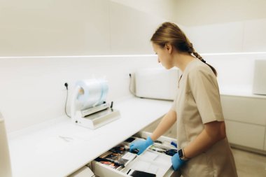 Modern bir klinikte kadın tıbbi profesyonel organizasyon araçları, hijyen ve sağlık hizmetlerinde hazırlık