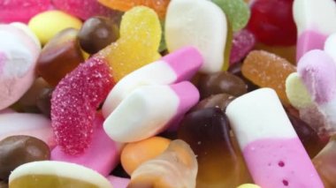 4K Yakın plan Renkli Şekerler Vibrant Jummy Bears, Dönen Tatlı Şeker Atlıkarınca, Şekerli Lezzetler, Sağlıksız İşlenmiş Çöp Yiyecekler, Diyabet Risk Faktörü ve Çeşit Şekerlemeler İçin Şekerlemeler