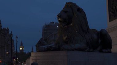 Trafalgar Meydanı 'ndan İkonik Aslan Heykeli' nin 4K 'dan Geceden Geceye Zaman Çizelgesi. Arkaplanda Büyük Ben, Londra Tarihi Simgeleri' nin bulutlu gece konsepti, Sonsuz Viktorya dönemi simgeleri.