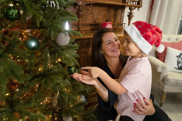 mother with child decorating vintage christmas tree