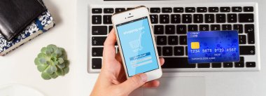 On-line alışveriş kavramı - on-line alışveriş sayfa ile dizüstü bilgisayar, kredi kartı ve eller holging telefon ile masaüstü