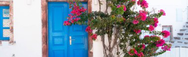 Çiçekli mavi ahşap kapı, Santorini adasının güzel detayları, Yunanistan