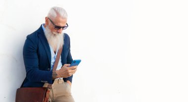 Üst düzey hippi, Avrupa 'nın açık caddesindeki bir telefonda sosyal medyayı yeniden canlandırıyor. Mutluluk, teknoloji ve yaşlılar yaşam tarzı kavramı.