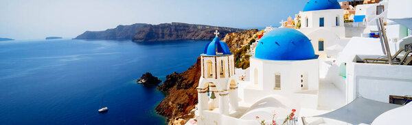 view of traditional greek village Oia of Santorini, with blue domes against sea and caldera, Greece, toned