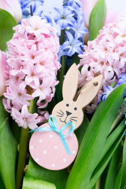 Paskalya sahnesinde taze sümbül çiçekleri ve yumurtalı Paskalya Tavşanı.