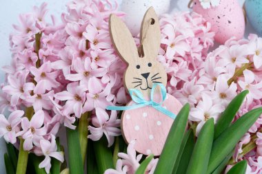 Paskalya sahnesinde taze sümbül çiçekleri ve yumurtalı Paskalya Tavşanı.