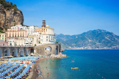 Atrani sahilinde mavi şemsiyeler ve deniz suyu, Amalfi, İtalya