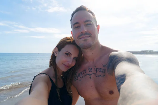 Happy young couple at the sea vacations doing selfie, summer vacations and relaxation