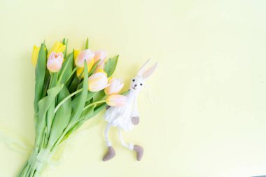 Paskalya sahnesinde laleler ve tavşancıklar açık sarı arka planda yatıyordu.