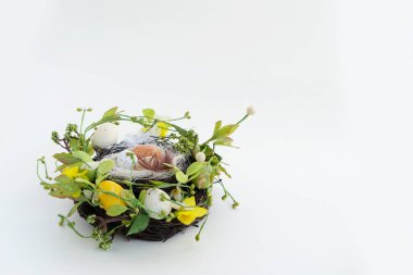 Yuvasında renkli yumurtalar, laleler ve tavşanlı Paskalya sahnesi.