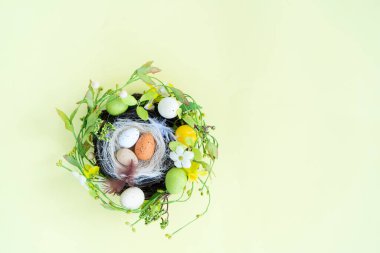 Yuvasında renkli yumurtalar olan Paskalya sahnesi, fotokopi alanı olan üst manzara