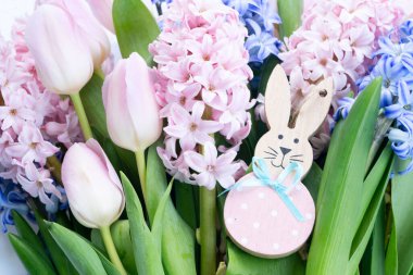 Paskalya sahnesinde taze sümbül çiçekleri ve yumurtalı Paskalya Tavşanı.