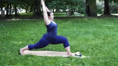 Woman and sports, exercise for weight loss in the fresh air. Happy curvy 40s woman doing workout stretch routine outdoor at city park