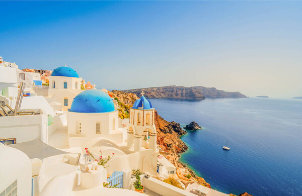 view of traditional greek village Oia of Santorini, with blue domes against sea and caldera, Greece